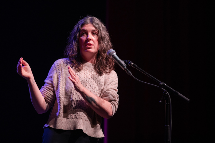 a woman shares her story on a microphone. 📷kmr studios